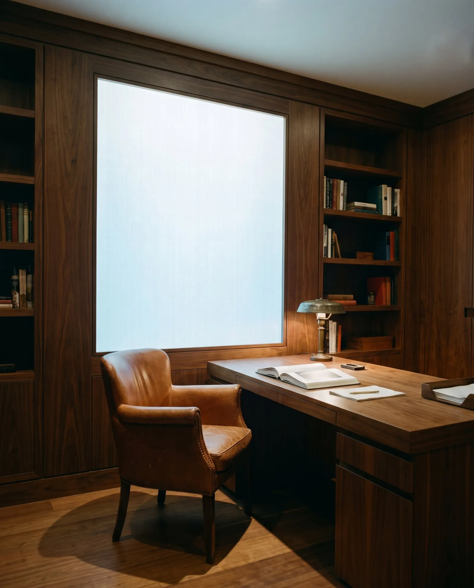 A windowless walnut study lit by a daylight panel